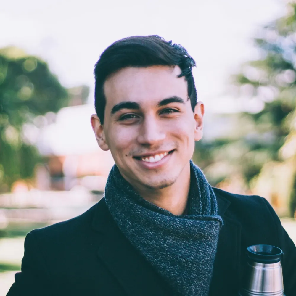 Outdoor portrait of a smiling man in a coat and scarf